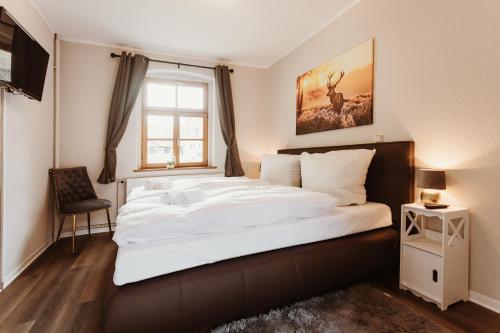 a bedroom with a large white bed with a window at Gutshof zu Quedlinburg in Quedlinburg