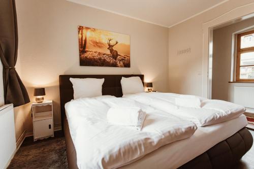 a bedroom with a large white bed in it at Gutshof zu Quedlinburg in Quedlinburg