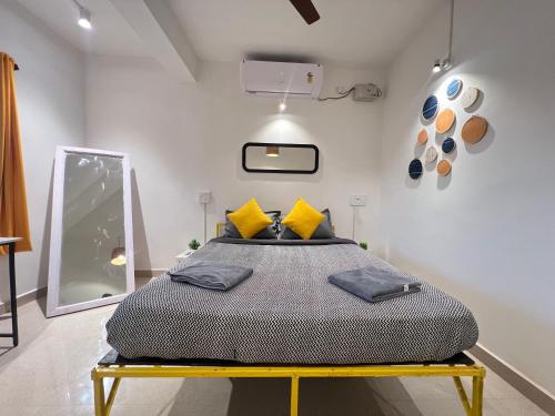 a bedroom with a large bed with yellow pillows at Whoopers Party Hostel, Palolem in Palolem