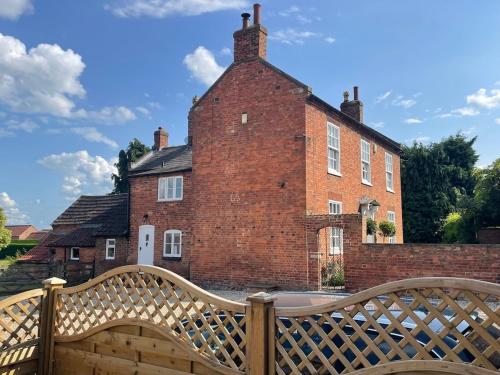 East StokeにあるThe Beautiful Barnのレンガ造りの建物前の木製のベンチ