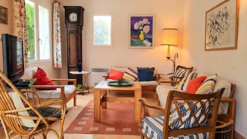 un salon avec un canapé, des chaises et une télévision dans l'établissement Saint Georges de Didonne - MAISON avec jardin clos - PROCHE COMMERCES, à Saint-Georges-de-Didonne