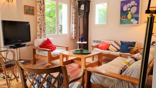 un salon avec un canapé et une télévision dans l'établissement Saint Georges de Didonne - MAISON avec jardin clos - PROCHE COMMERCES, à Saint-Georges-de-Didonne