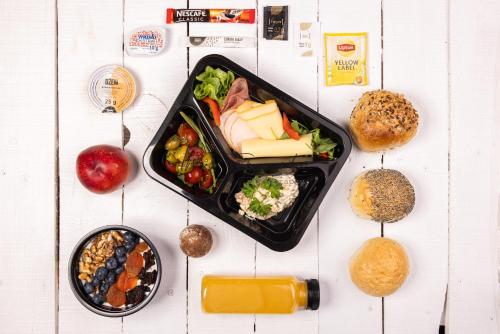 uma mesa com uma bandeja de comida e um prato de comida em Krupówki 17 Resort & SPA em Zakopane