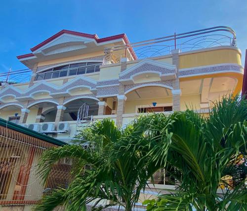 a building with palm trees in front of it at Princesa Sunset Homes in Puerto Princesa City