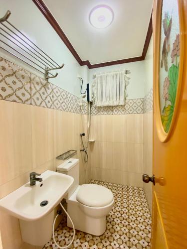 a bathroom with a white toilet and a sink at Princesa Sunset Homes in Puerto Princesa City