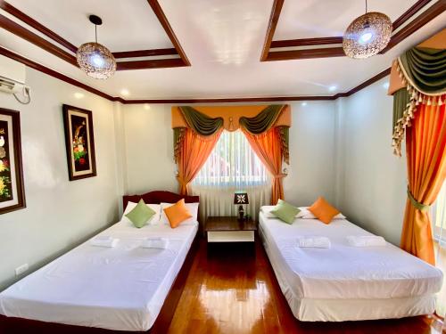 a room with two beds and a window at Princesa Sunset Homes in Puerto Princesa City