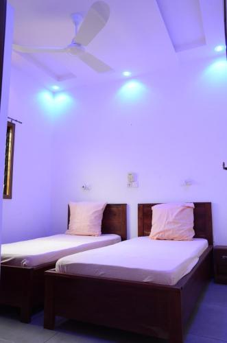 two beds in a room with lights on the ceiling at Maison de la Volonté Divine, Simple et empreint de sérénité in Abomey-Calavi
