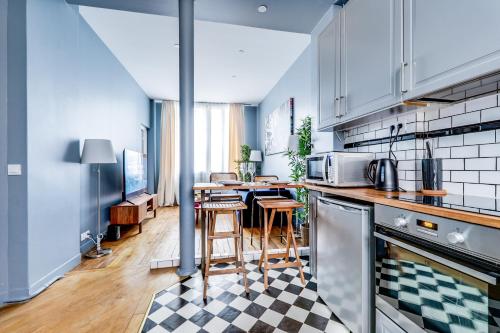 une cuisine avec une table et un comptoir dans l'établissement Buttes-Chaumont - Fully-Equipped, à Paris