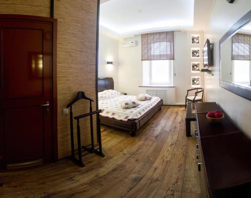 サマラにあるGostiniy Dvor on Troitskayaのベッド1台とソファが備わる小さな客室です。