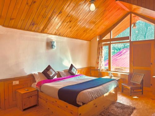 Un dormitorio con una cama y una ventana grande. en Frostvale Private 3 Bedroom Cottage, en Manali