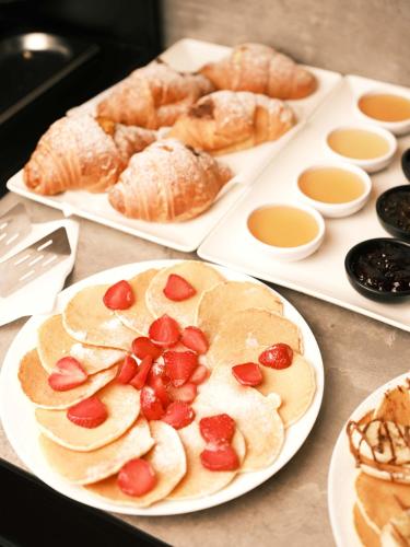 a table topped with plates of pastries and bread at The Central View Boutique Hotel in Vlorë