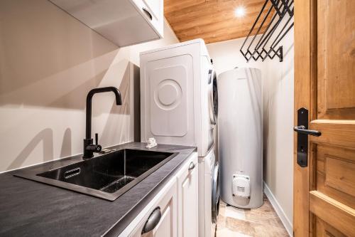 une cuisine avec un évier et un réfrigérateur dans l'établissement Chalet Olea Chamonix - by EMERALD STAY, à Chamonix-Mont-Blanc