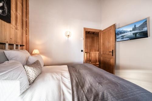 - une chambre avec un lit blanc et une porte dans l'établissement Chalet Olea Chamonix - by EMERALD STAY, à Chamonix-Mont-Blanc