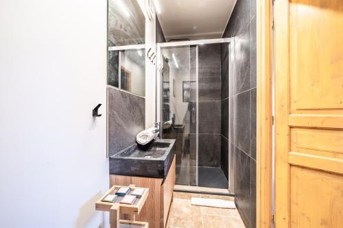 La salle de bains est pourvue d'une douche et d'un lavabo noir. dans l'établissement Chalet Olea Chamonix - by EMERALD STAY, à Chamonix-Mont-Blanc
