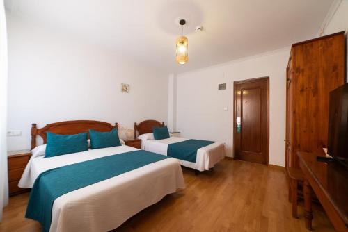 a hotel room with two beds and a television at Las Palmeras in Crevillente