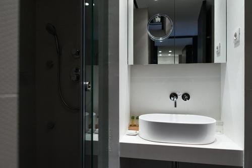 a bathroom with a white sink and a mirror at Alexandra Barcelona Hotel, Curio Collection by Hilton in Barcelona