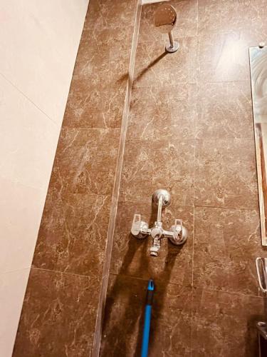 a shower with a faucet in a bathroom at Golden palace studio in Ghaziabad