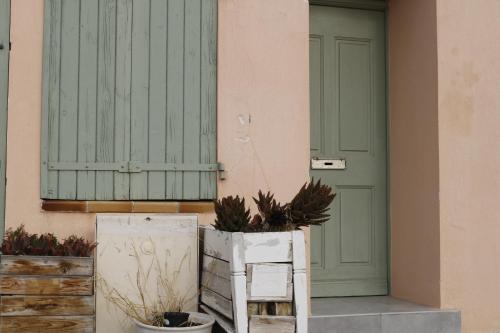 un bâtiment avec une porte verte et une usine dans l'établissement Le charme de la Venise provençale, à Martigues