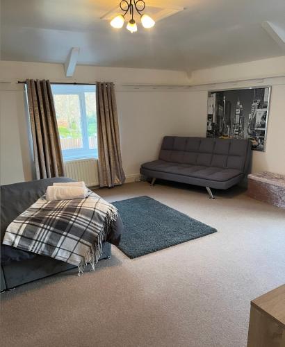 a living room with a bed and a couch at Beautiful Countryside Cottage Alnwick Northumberland in Alnwick