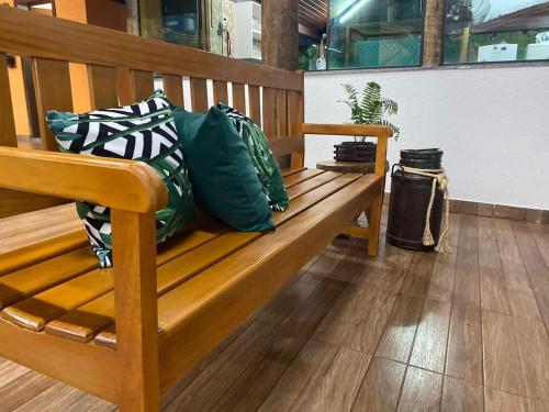 a wooden bench with pillows sitting on it at Chalés Riacho da Serra Capitólio in Guapé