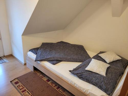 a bed with black pillows on it in a room at FeWo Köt- 3 Ferienwohnungen im historischen Köthener Stadtkern in Köthen