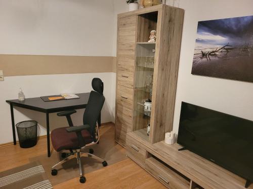 a desk and a chair in a room with a television at FeWo Köt- 3 Ferienwohnungen im historischen Köthener Stadtkern in Köthen