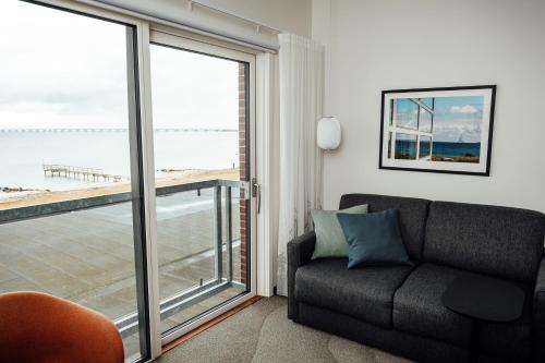 a living room with a couch and a large window at Nyborg Strand Hotel & Konference in Nyborg