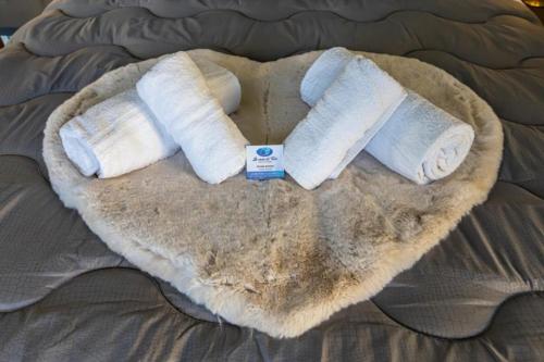 a group of three rolled towels on a bed at XX Settembre 74 - Terrazza Sul Mare in Alassio