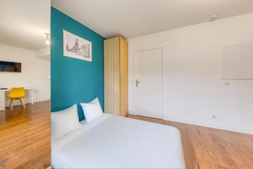 - une chambre avec un lit blanc et un mur bleu dans l'établissement Refuge confortable - Terrasse - Gare Villiers à 2 min, à Villiers-sur-Marne
