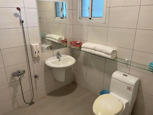 a bathroom with a toilet and a sink at 秘密客旅宿 in Xiaoliuqiu