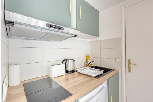 une petite cuisine avec un évier et une cuisinière dans l'établissement Refuge confortable - Terrasse - Gare Villiers à 2 min, à Villiers-sur-Marne