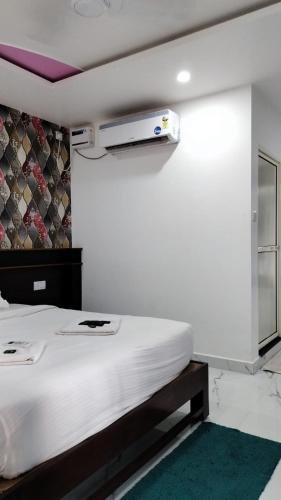 a bedroom with a white bed with a projector on the wall at Antonios Calangute beach in Calangute