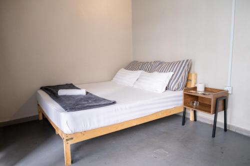 a small bed in a room with a night stand at Pak Fook Hotel Chow Kit in Kuala Lumpur