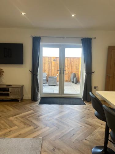 a living room with a sliding glass door at Mill House The Lodge in Upwell