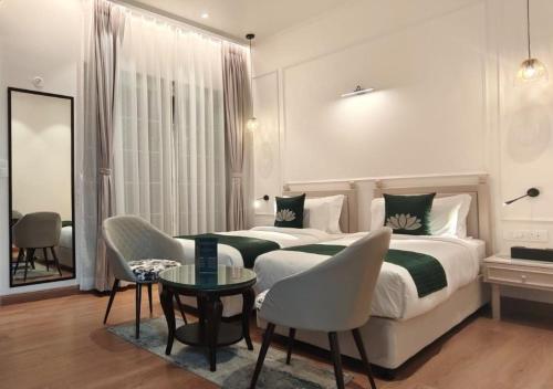 a bedroom with a large bed and a table and chairs at Narayan Kothi in Varanasi