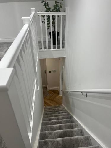 a staircase in a house with a white stair case at Mill House The Lodge in Upwell