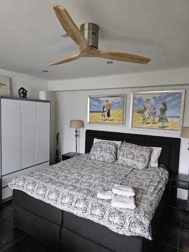 a bedroom with a bed with a ceiling fan at NamaStee aan Zee in Vlissingen