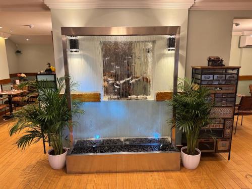 a large aquarium in a room with two potted plants at The Bell and Bottle in Hedgerley