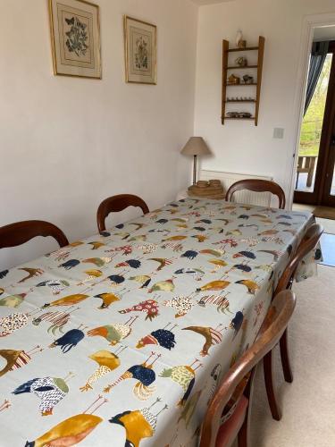 a table with a table cloth with birds on it at The Tall Barn in Rose Ash