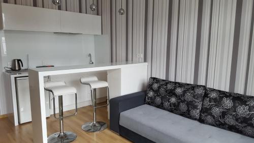 a living room with a couch and a bar with stools at StudioSpanie Apartament Baltic in Gdynia