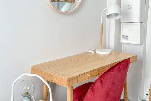 - un bureau avec une chaise rouge et un miroir dans l'établissement Flexliving - Studio - Parodi, à Paris