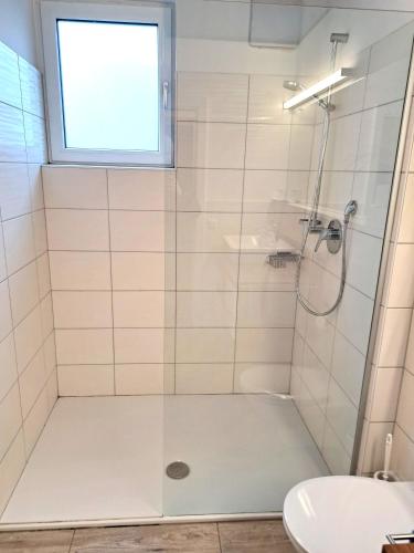 a shower with a glass door in a bathroom at Ferienwohnungen Oliver Bayer in Bad Schallerbach