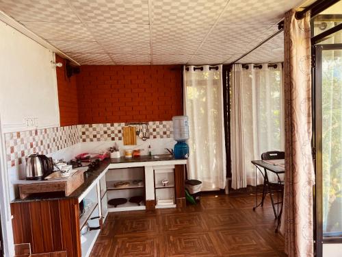 a small kitchen with a counter and a table at Avocado Accommodations in Khadkagaon