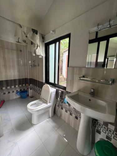 a bathroom with a toilet and a sink at Avocado Accommodations in Khadkagaon