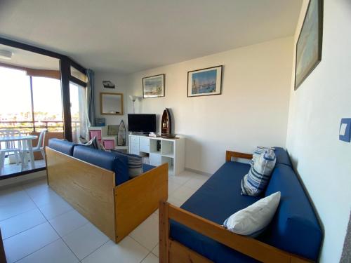 un salon avec un canapé bleu et une télévision dans l'établissement Le Barcarès pour 4 personnes L'Evasion Catalane, au Barcarès
