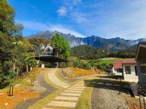 a path leading to a house with mountains in the background at The Pampines Villa, Mount Kinabalu in Ranau