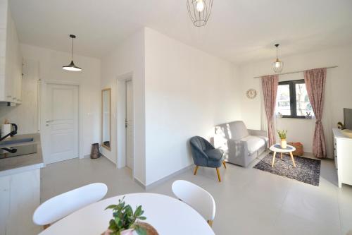 a white living room with a table and chairs at Green Ranch Stara Maslina in Kotor