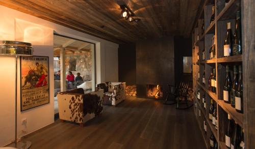 a room with a fireplace and a room with wine bottles at Golfhotel Sonne in Siusi
