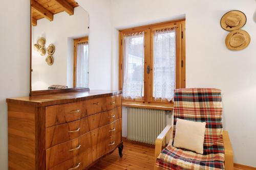 a dressing room with a dresser and a chair at Casa Pòlse in Baselga di Pinè