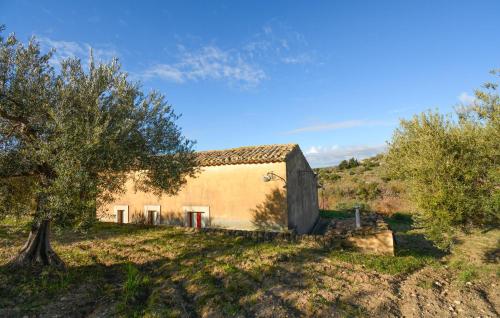an old house in a field with trees at Casa Giudice in Chiaramonte Gulfi